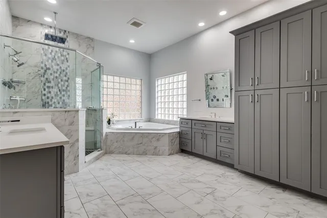 a large bathroom with a tub sink shower and mirror