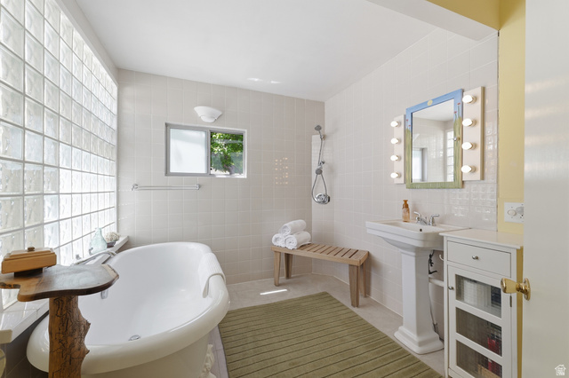 365 North Main Street Fillmore, UT 84631 - Photo 49 of 51 Bathroom featuring a freestanding soaking tub, a full glass block wall, a pedestal sink, and a tiled shower area