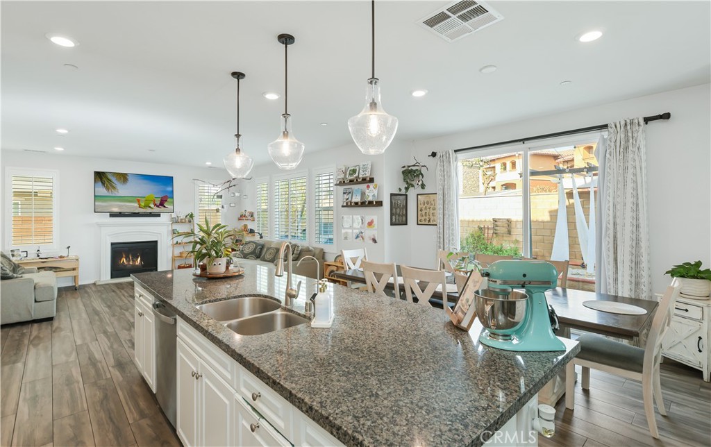 13170 Winslow Drive Rancho Cucamonga, CA 91739 - Photo 10 of 57 a kitchen with granite countertop a table chairs in it and wooden floors