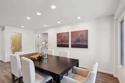 a dining room with furniture and a potted plant