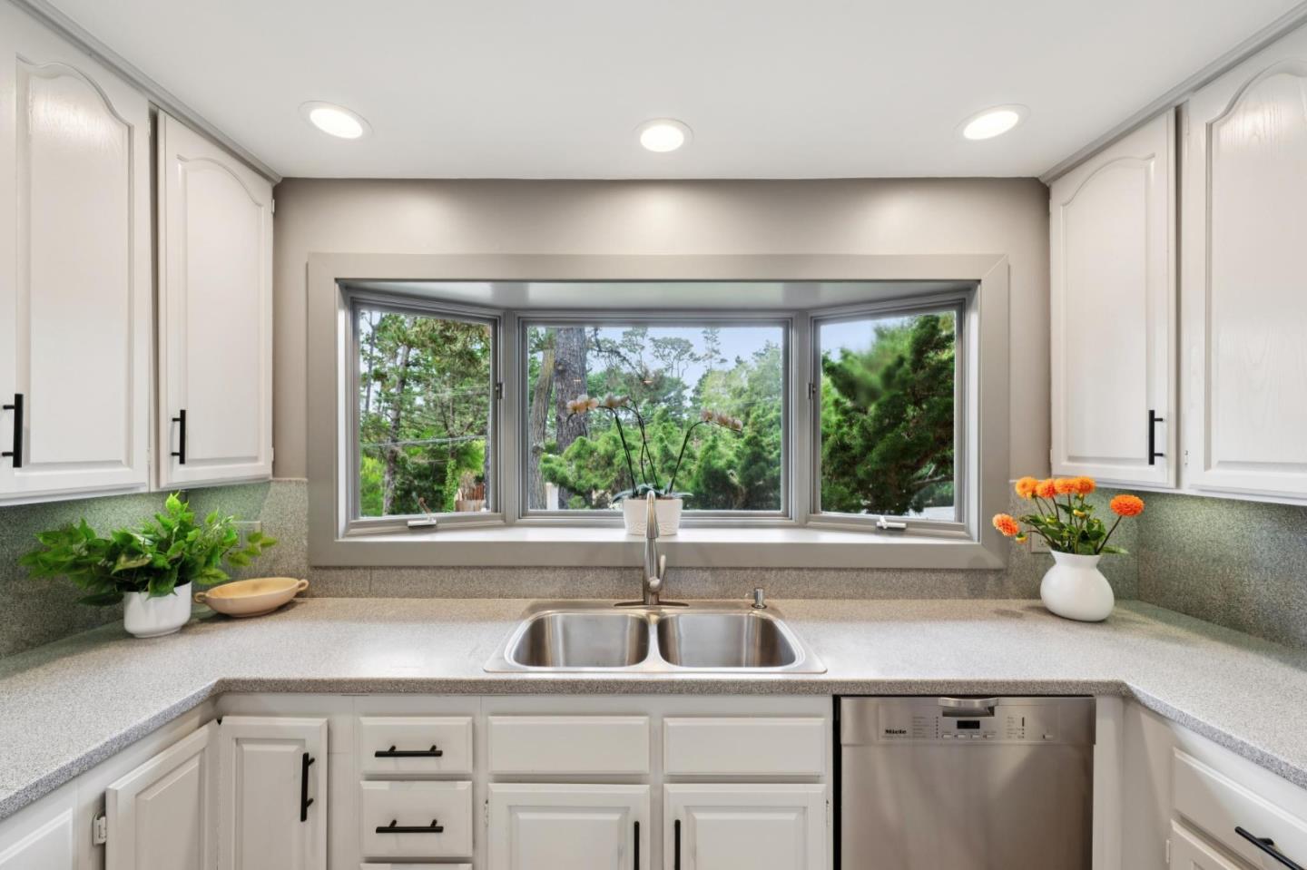 4083 Sunset Lane Pebble Beach, CA 93953 - Photo 23 of 54 a kitchen with stainless steel appliances white cabinets and a large window