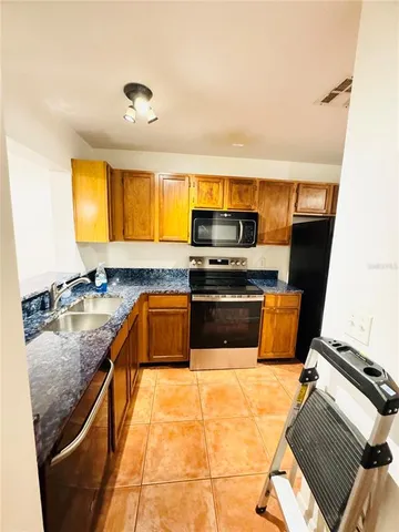 a kitchen with stainless steel appliances granite countertop a sink and a stove