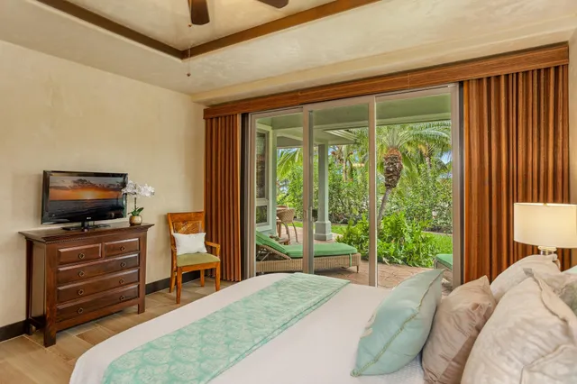 a large bed sitting in a bedroom next to a window