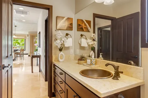 a bathroom with a sink vanity granite tub shower and a mirror
