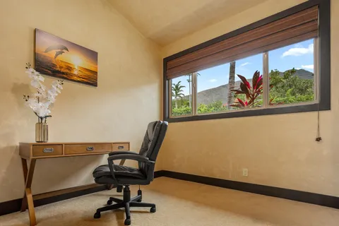 a view of a workspace with furniture and a window