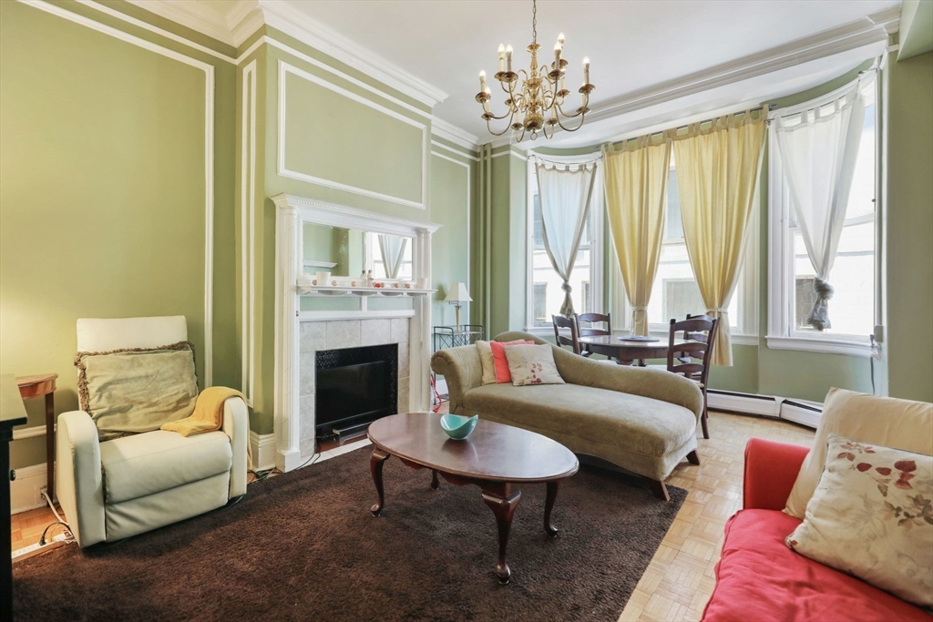 21 Beacon Street, Unit 4S Boston, MA 02108 - Photo 2 of 16 a living room with furniture a chandelier and a fireplace