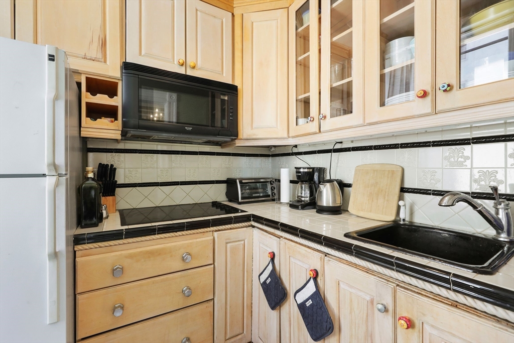 21 Beacon Street, Unit 4S Boston, MA 02108 - Photo 5 of 16 a kitchen with granite countertop a sink and a microwave