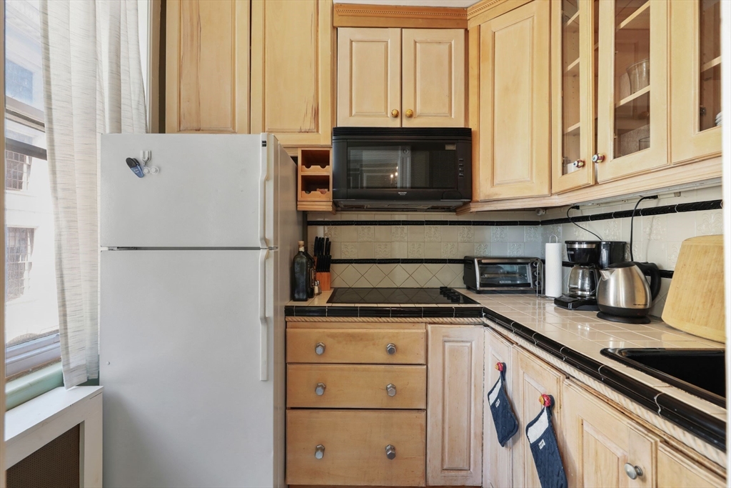 21 Beacon Street, Unit 4S Boston, MA 02108 - Photo 6 of 16 a kitchen with granite countertop a refrigerator and a sink