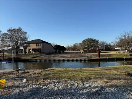 a view of house with river and trees in the background