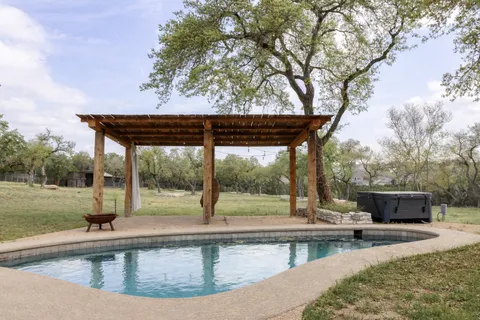 a view of a swimming pool with a patio and a yard