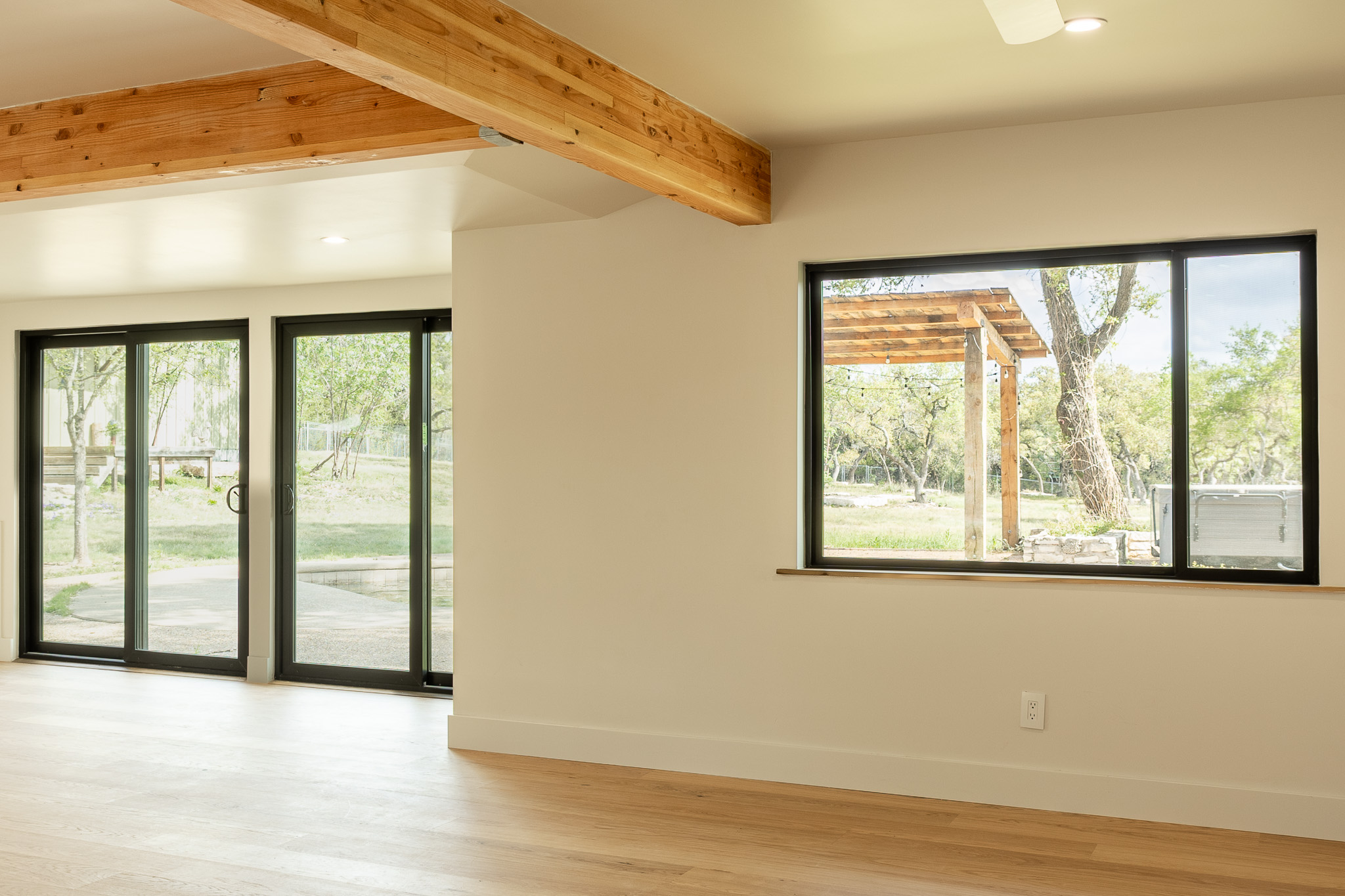 8717 South View Road Austin, TX 78737 - Photo 9 of 36 a view of an empty room with wooden floor and a window