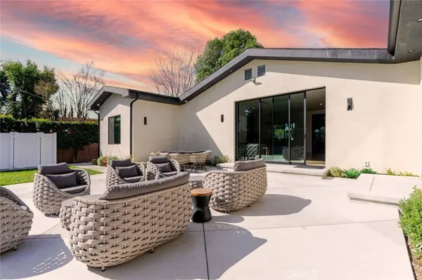 a view of a house with backyard and sitting area