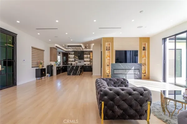 a living room with furniture a chandelier and a flat screen tv