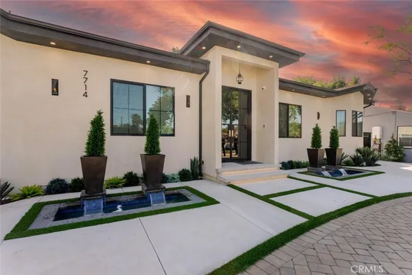 a front view of a house with a garden and yard