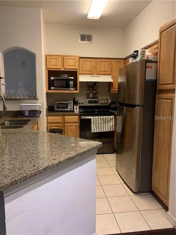 3446 Soho Street, Unit 101 Orlando, FL 32835 - Photo 2 of 9 a kitchen with stainless steel appliances granite countertop a refrigerator a stove and a sink with granite countertops