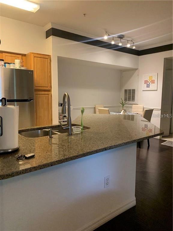 3446 Soho Street, Unit 101 Orlando, FL 32835 - Photo 3 of 9 a kitchen with a sink and a refrigerator