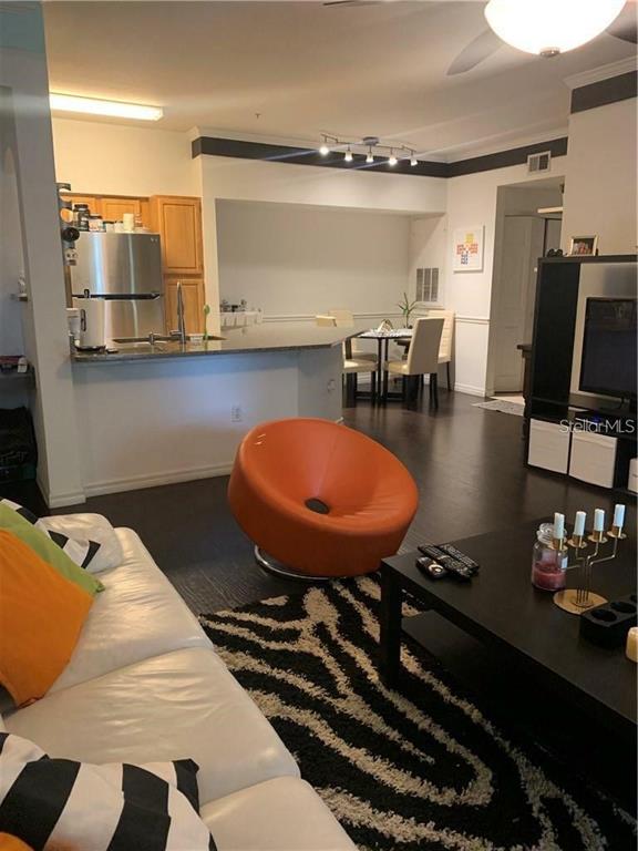 3446 Soho Street, Unit 101 Orlando, FL 32835 - Photo 5 of 9 a kitchen with a table chairs and appliances