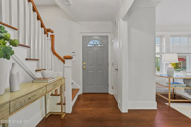 a view of an entryway with wooden floor and staircase