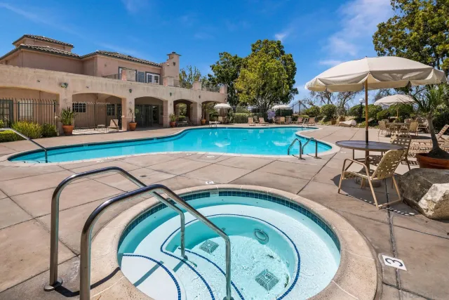 a view of a swimming pool with outdoor seating and plants