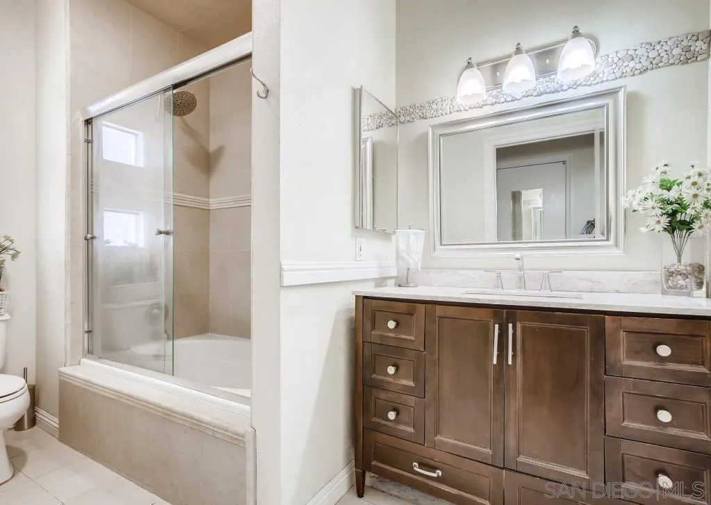 17161 Alva Road, Unit 1211 San Diego, CA 92127 - Photo 5 of 17 a bathroom with a granite countertop sink mirror toilet and bathtub