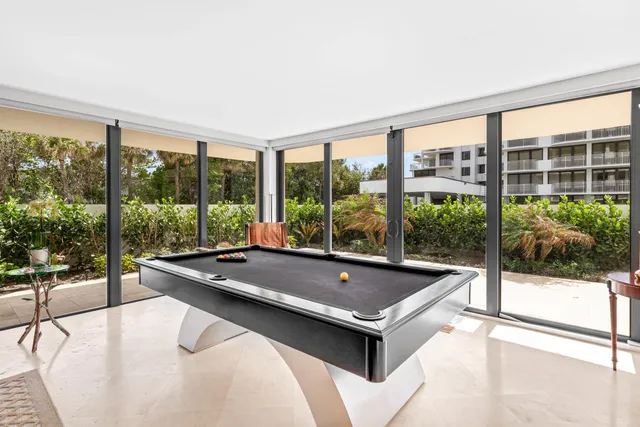 a room with pool table and windows