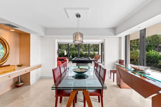 a dining room with furniture a chandelier and wooden floor
