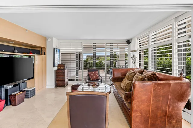 a living room with furniture a large window and a flat screen tv
