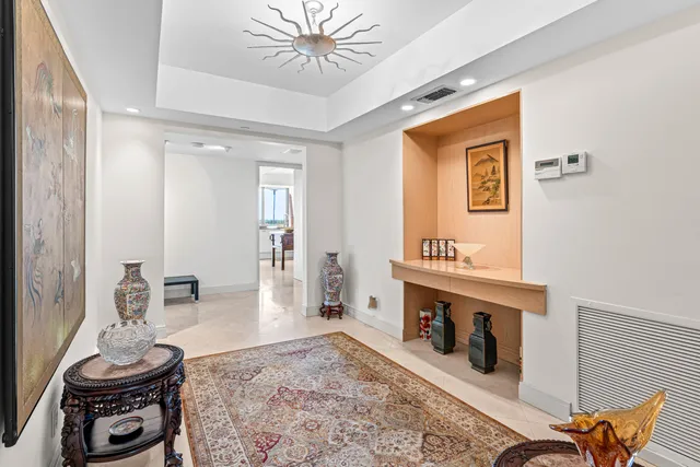 a view of a livingroom with furniture a fireplace and chandelier