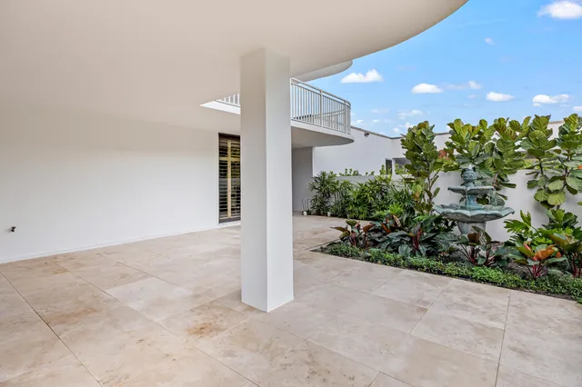 a view of a house with a yard and potted plants