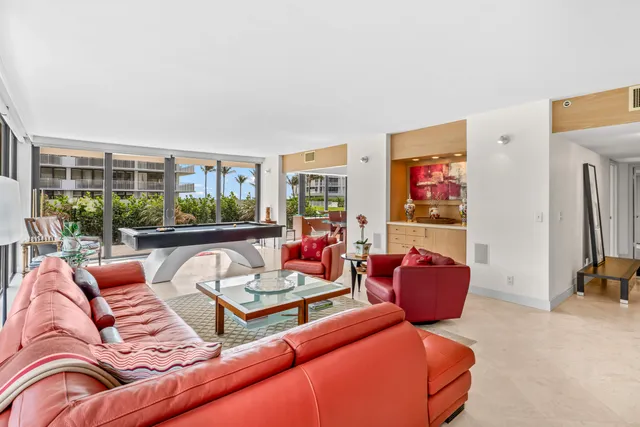 a living room with furniture a floor to ceiling window and couch