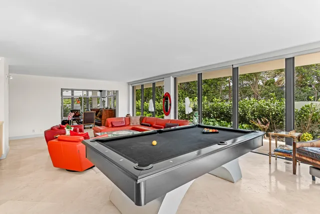 a room with pool table and windows