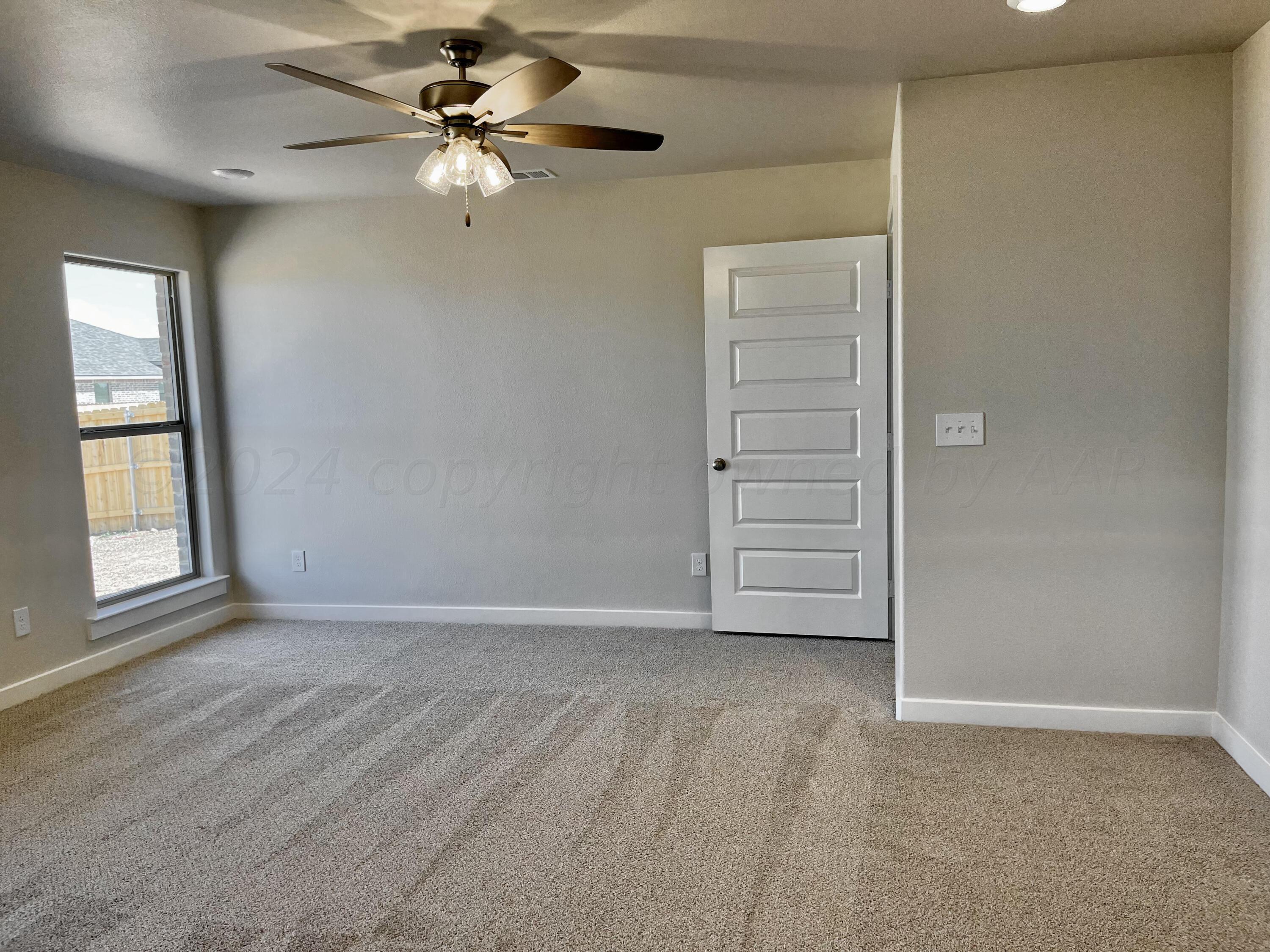 7515 Frazier Road Amarillo, TX 79119 - Photo 11 of 23 an empty room with windows and fan