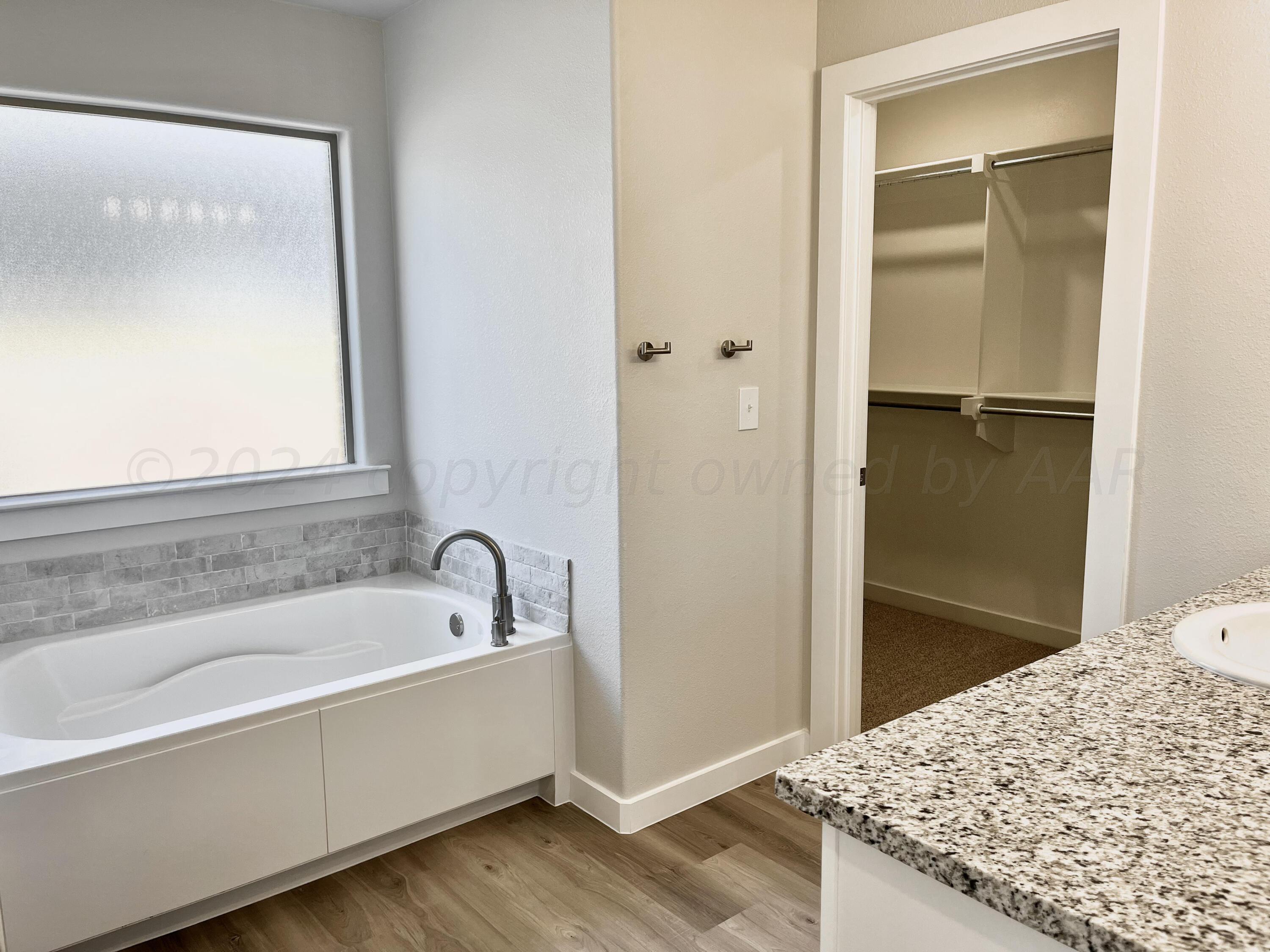 7515 Frazier Road Amarillo, TX 79119 - Photo 12 of 23 a bathroom with a granite countertop tub sink and mirror