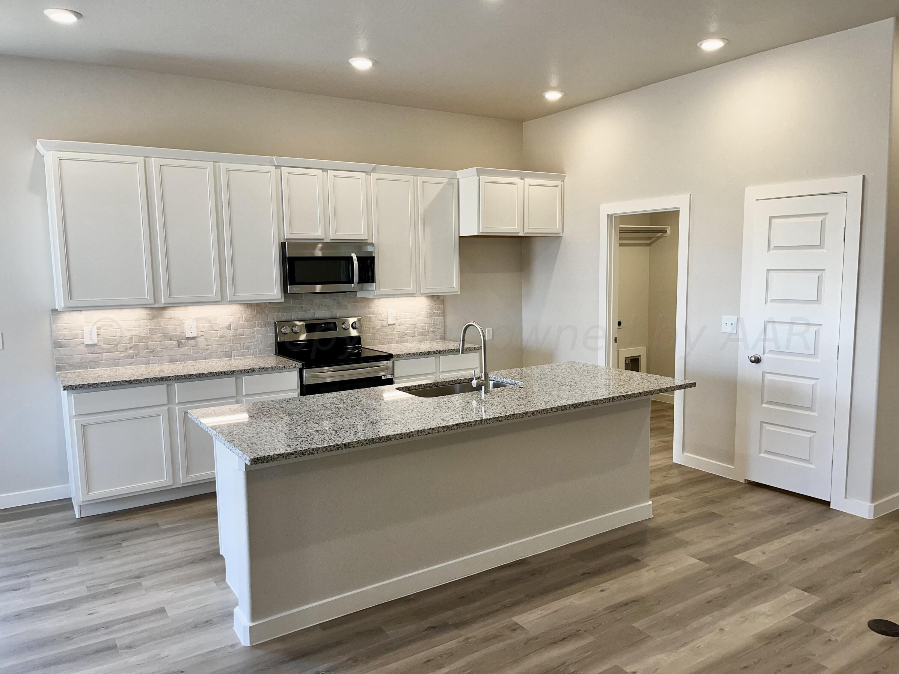 7515 Frazier Road Amarillo, TX 79119 - Photo 16 of 23 a kitchen with a refrigerator and a stove top oven