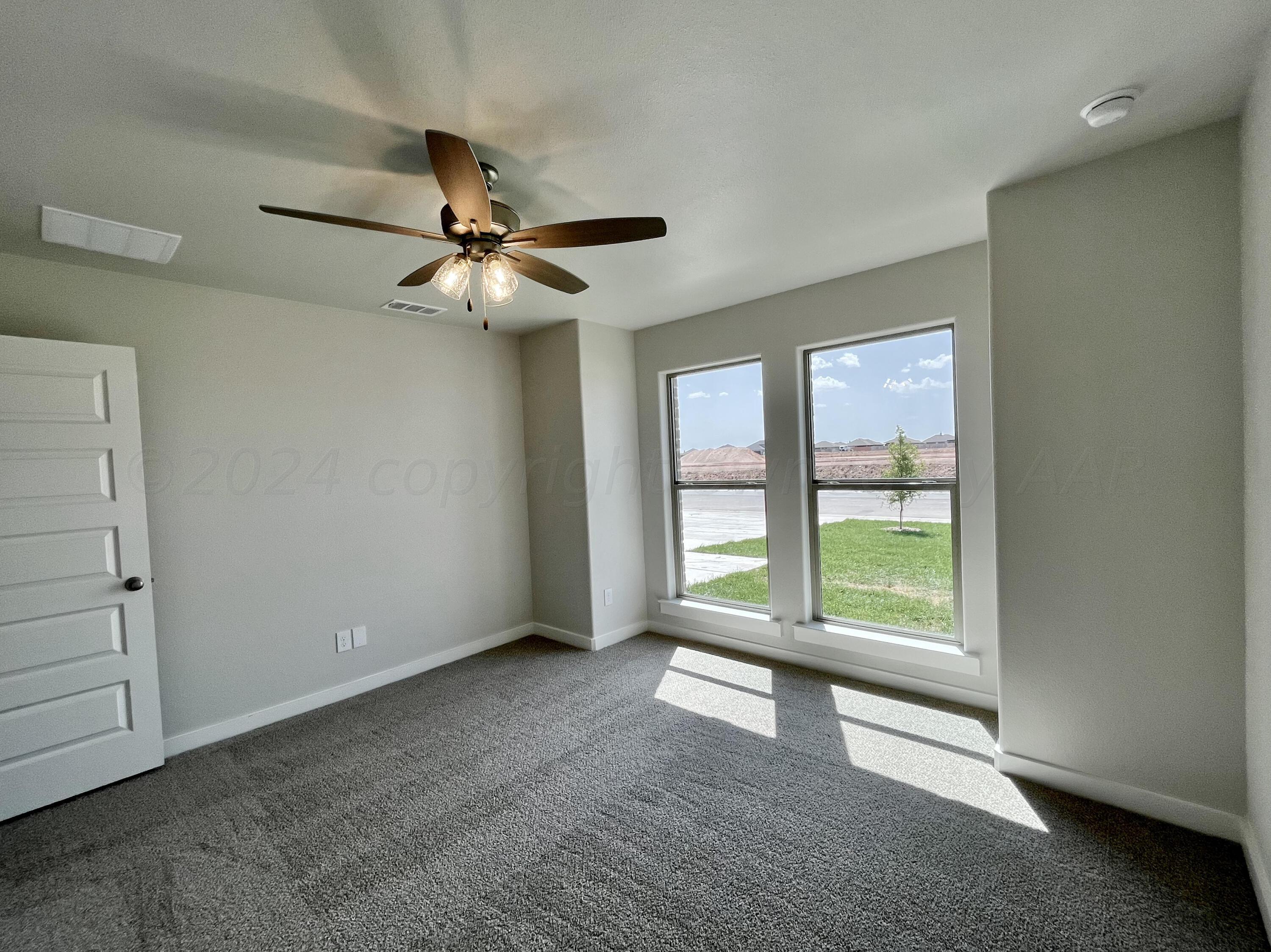 7515 Frazier Road Amarillo, TX 79119 - Photo 20 of 23 an empty room with windows and ceiling fan view
