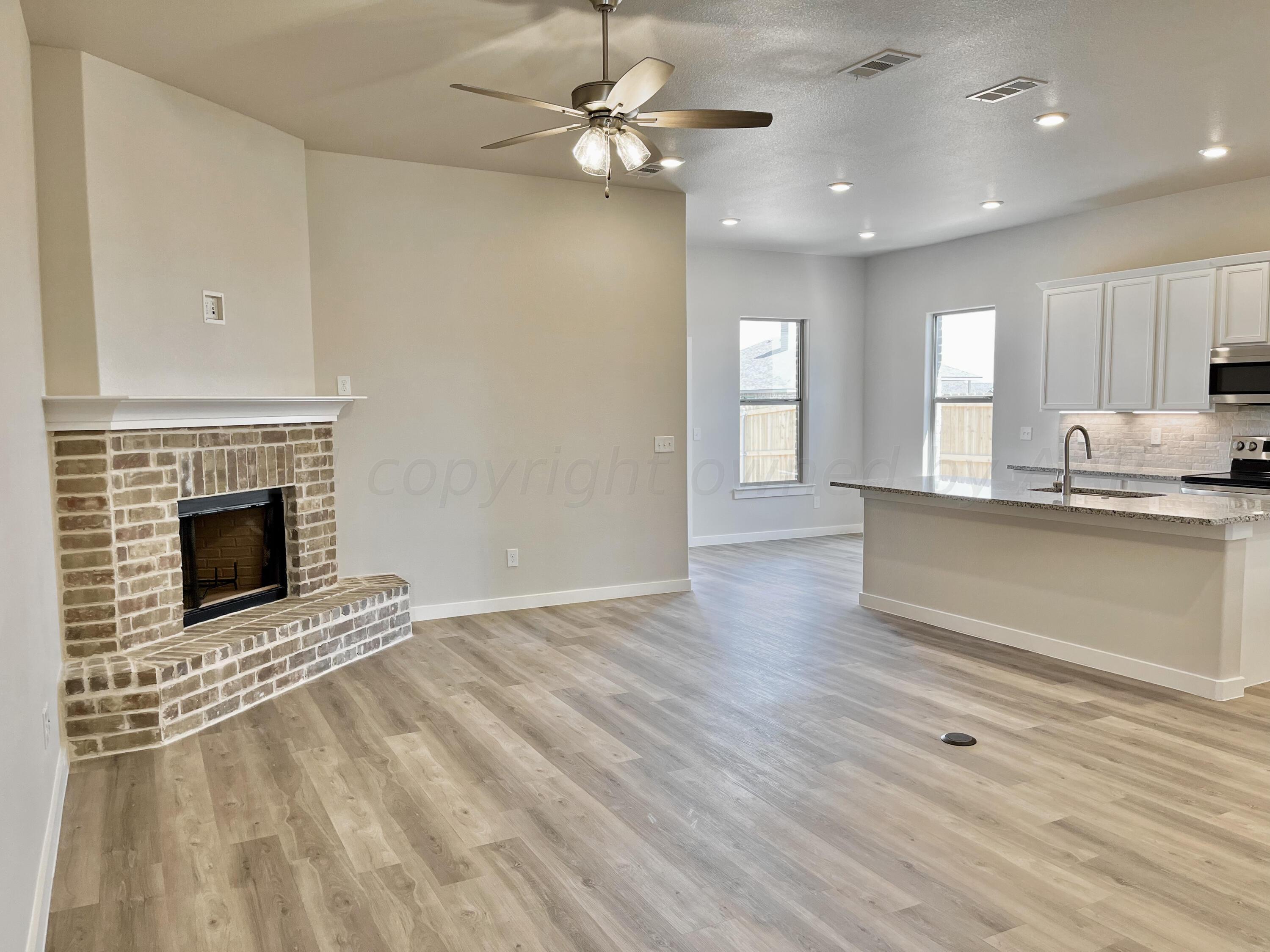 7515 Frazier Road Amarillo, TX 79119 - Photo 3 of 23 a view of an empty room with a kitchen and a fireplace
