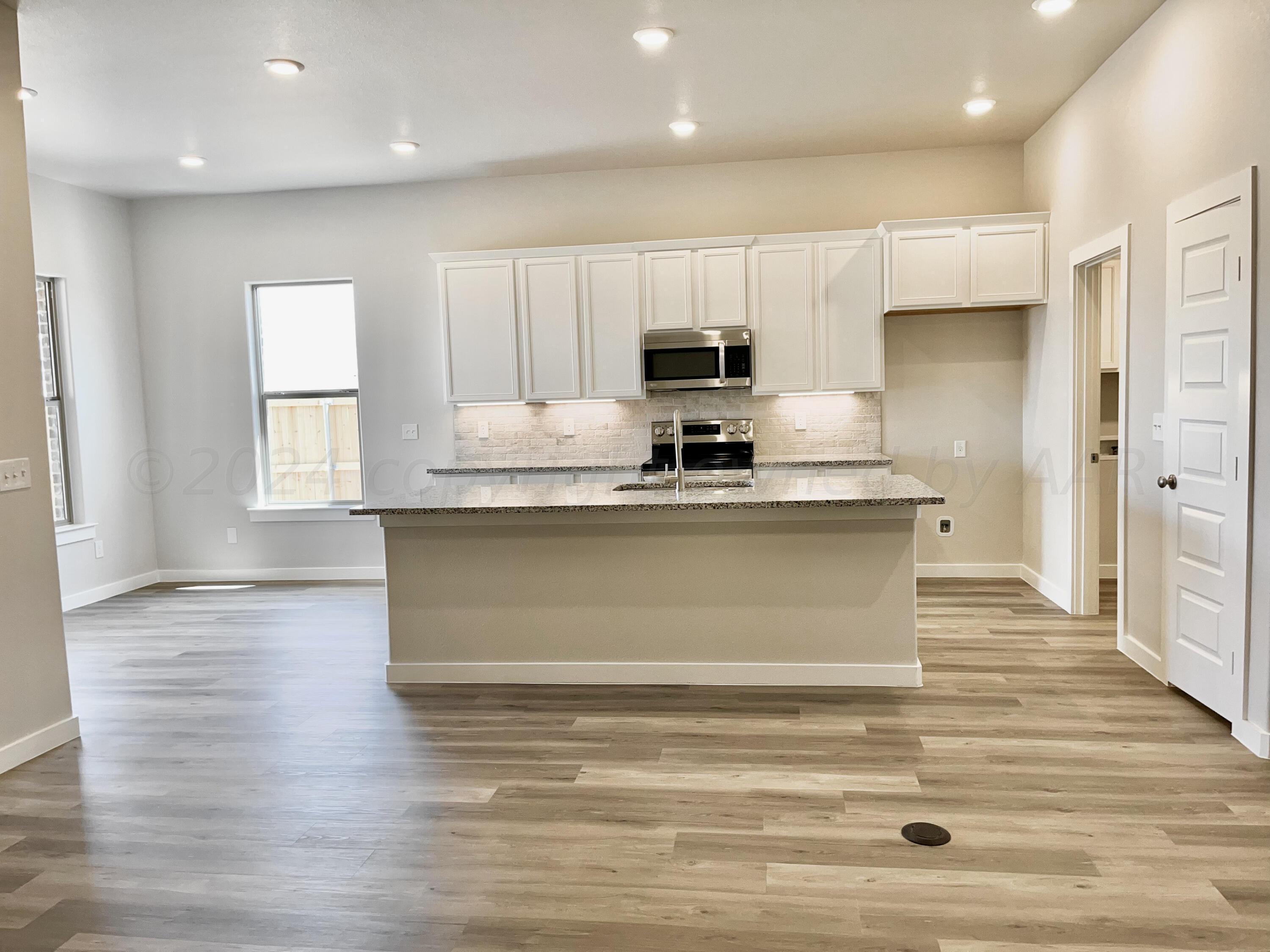 7515 Frazier Road Amarillo, TX 79119 - Photo 4 of 23 a view of a kitchen with granite countertop white cabinets and stainless steel appliances