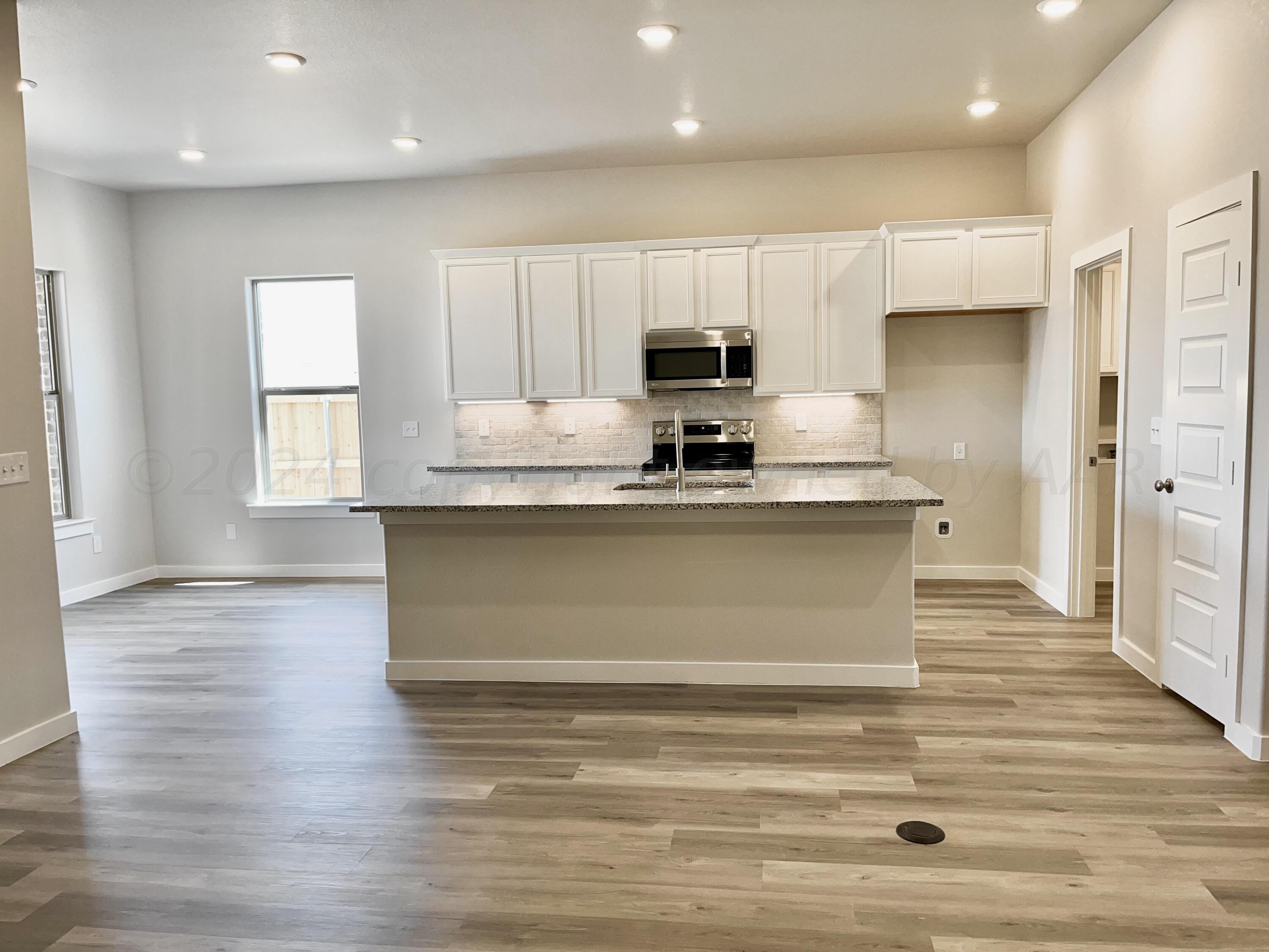 7515 Frazier Road Amarillo, TX 79119 - Photo 5 of 23 a view of a kitchen with granite countertop white cabinets and stainless steel appliances
