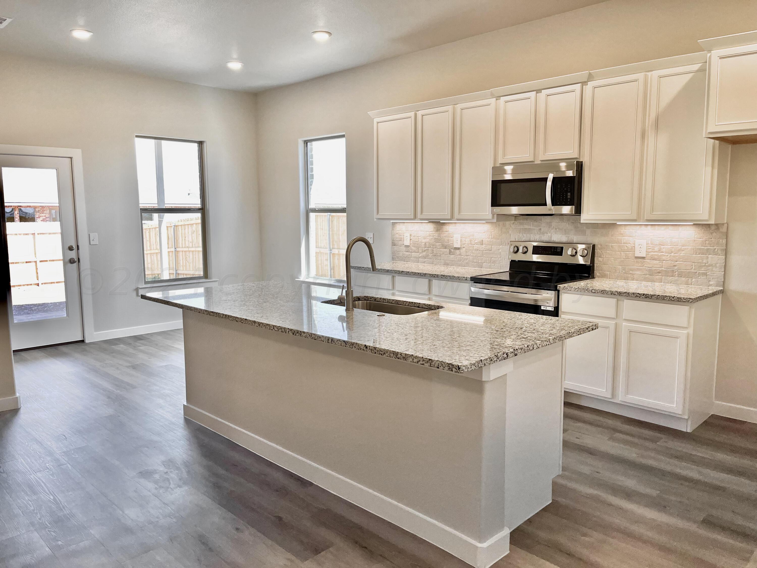 7515 Frazier Road Amarillo, TX 79119 - Photo 6 of 23 a kitchen with stainless steel appliances granite countertop a stove a sink and white cabinets