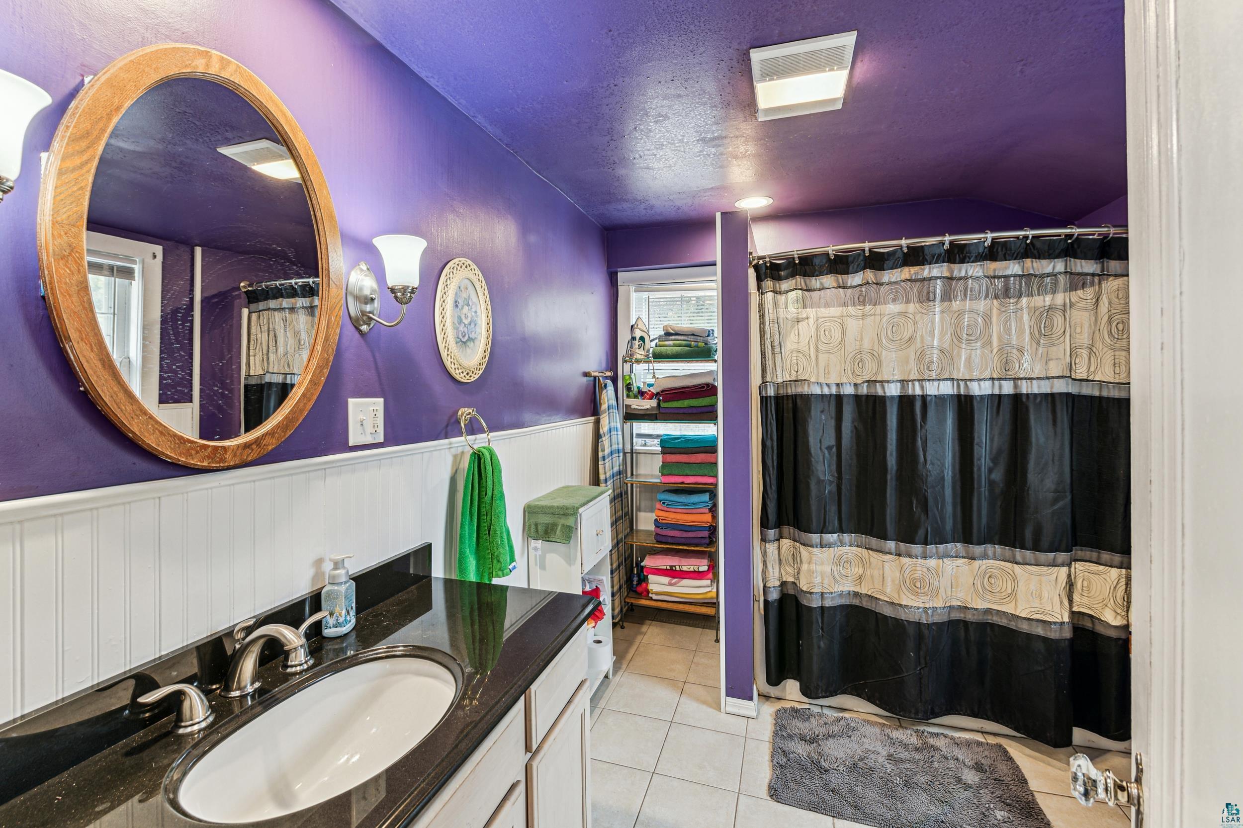 2111 Lakeview Drive Duluth, MN 55803 - Photo 14 of 21 Full bathroom with visible vents, a textured ceiling, wainscoting, tile patterned flooring, and vanity
