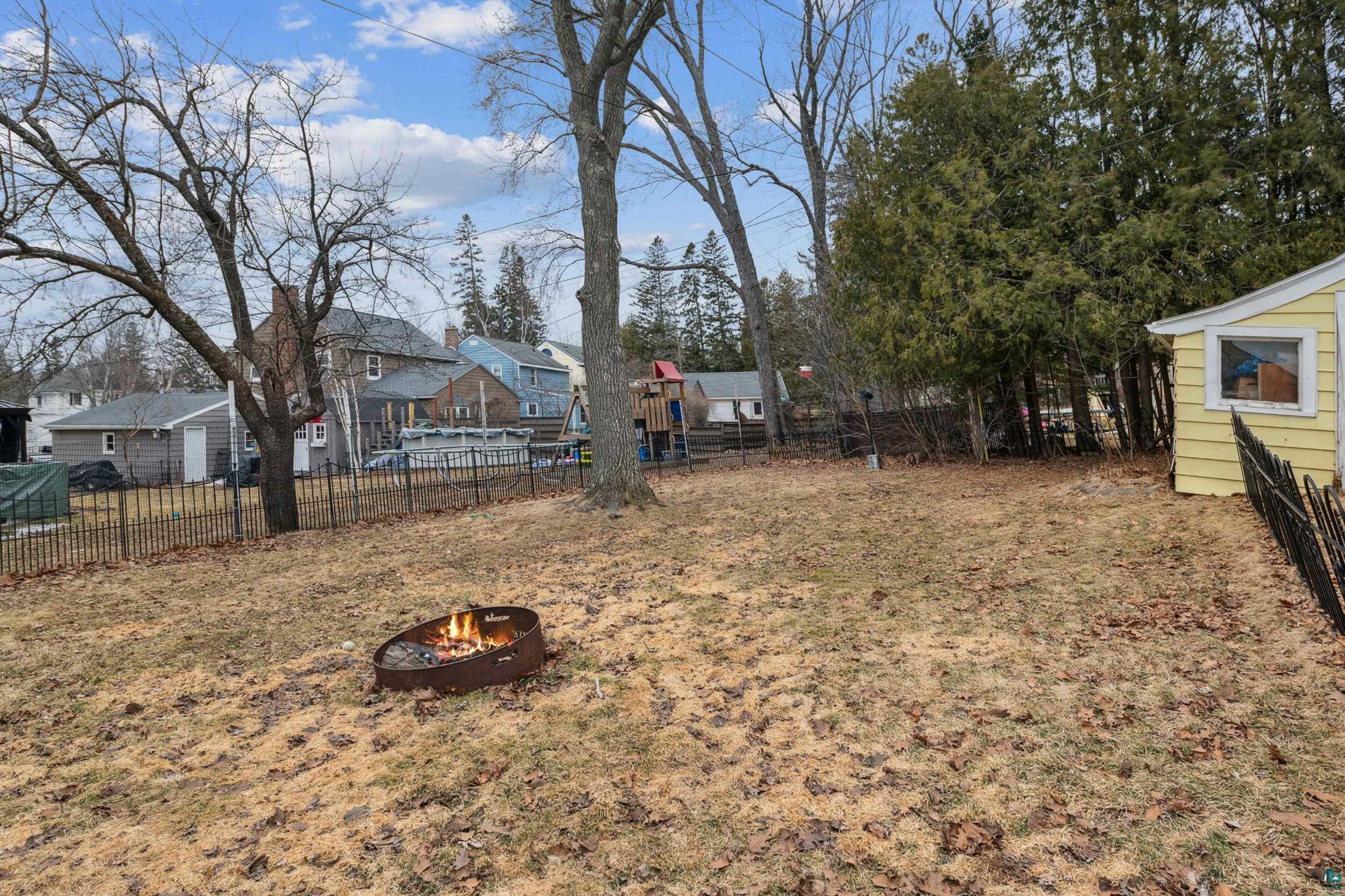 2111 Lakeview Drive Duluth, MN 55803 - Photo 20 of 21 View of yard featuring a residential view, an outdoor fire pit, and fence