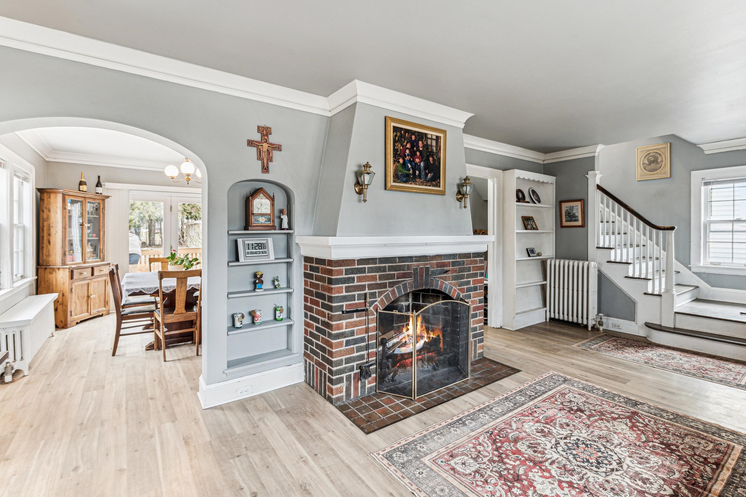 2111 Lakeview Drive Duluth, MN 55803 - Photo 5 of 21 Living area featuring wood finished floors, radiator heating unit, a fireplace, arched walkways, and ornamental molding