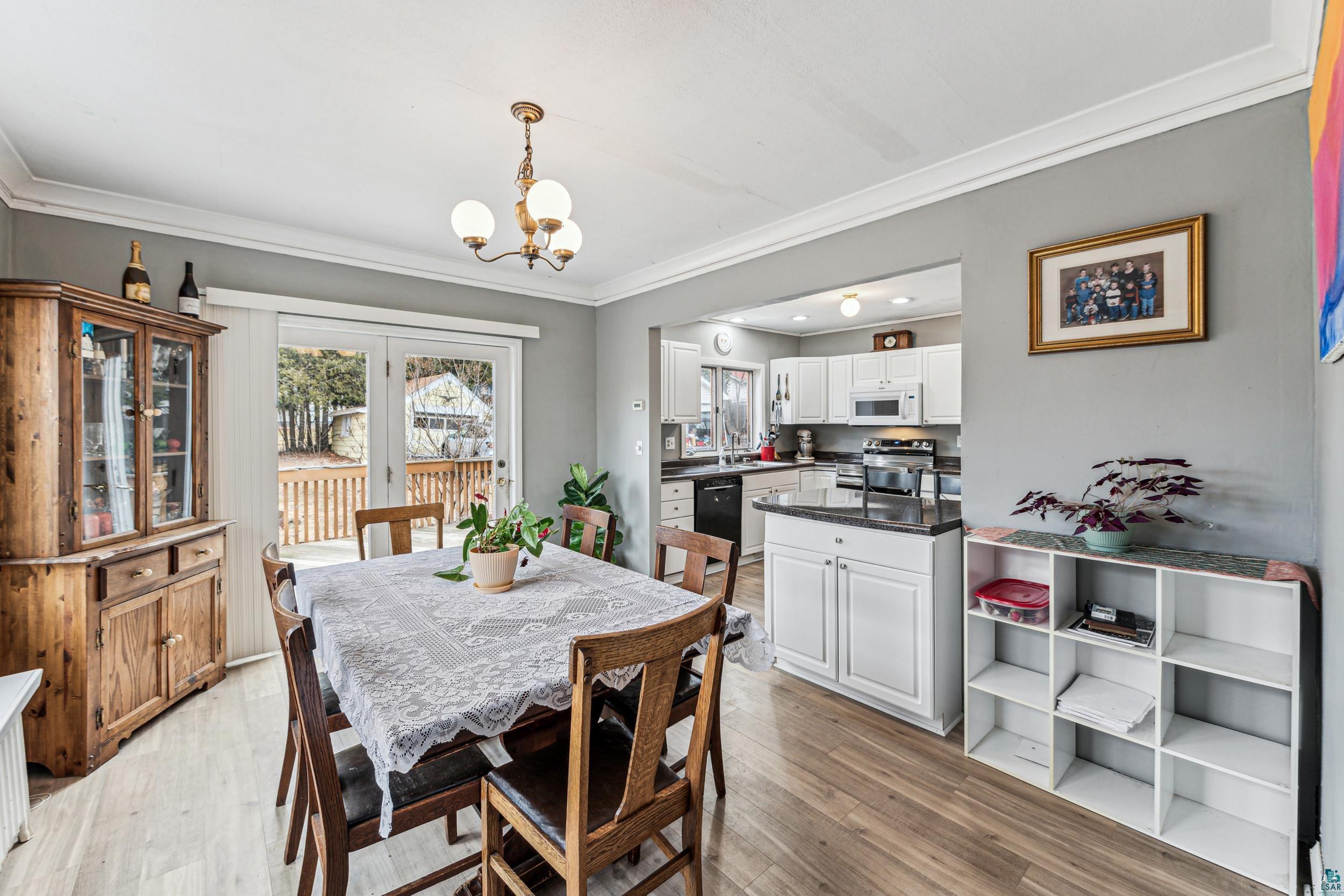 2111 Lakeview Drive Duluth, MN 55803 - Photo 6 of 21 Dining room featuring ornamental molding, light wood finished floors, and a chandelier