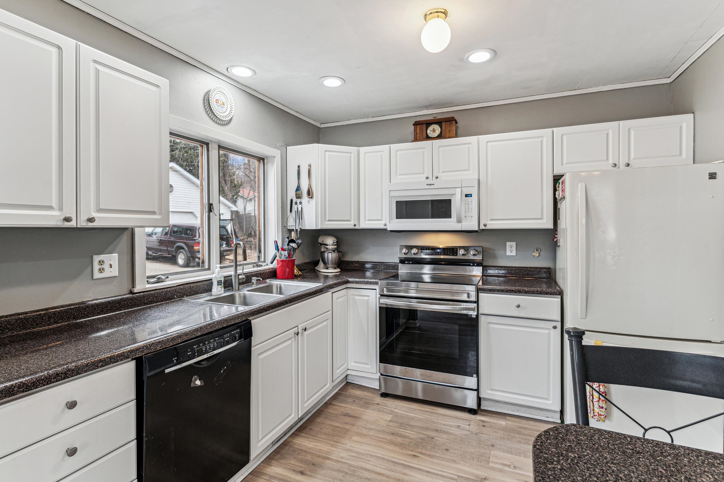 2111 Lakeview Drive Duluth, MN 55803 - Photo 9 of 21 Kitchen with a sink, white appliances, dark countertops, and white cabinets