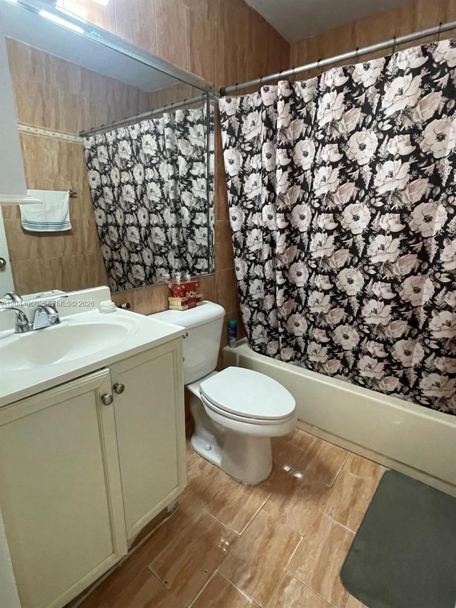7681 Northwest 178th Terrace Hialeah, FL 33015 - Photo 8 of 11 a bathroom with a toilet and a shower curtain