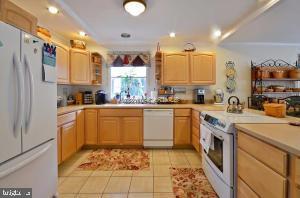 12606 Balte Road Ocean City, MD 21842 - Photo 14 of 51 a kitchen with stainless steel appliances a sink a stove a refrigerator cabinets and a window