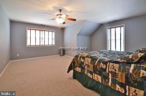 12606 Balte Road Ocean City, MD 21842 - Photo 30 of 51 a bedroom with a large bed and a chandelier