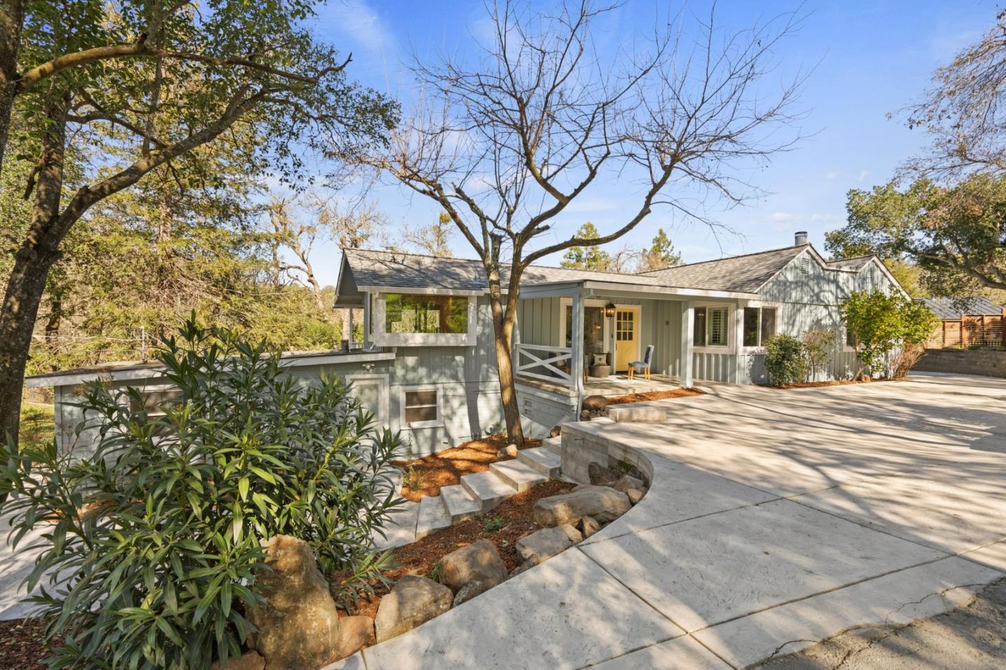 front view of a house with a large tree