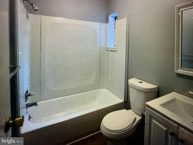 a white toilet sitting next to a bathtub