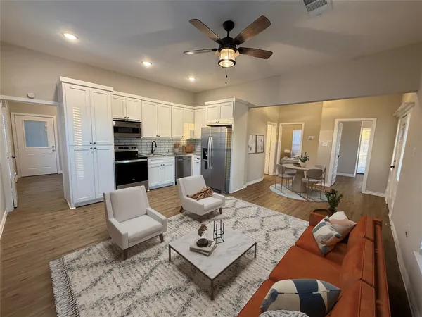 a living room with stainless steel appliances kitchen island furniture and a view of kitchen